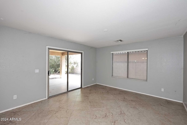 unfurnished room with visible vents and baseboards