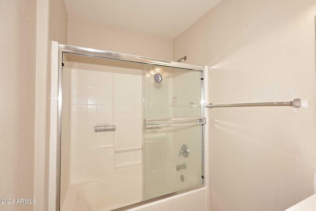 bathroom with combined bath / shower with glass door