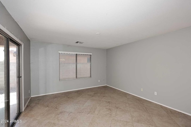 spare room featuring visible vents and baseboards