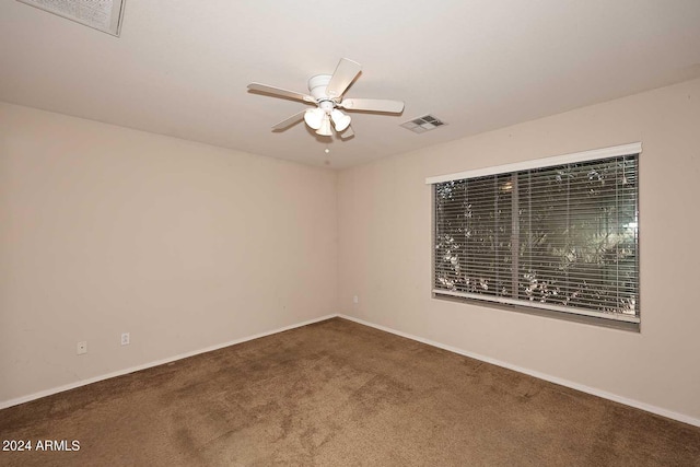 empty room with carpet flooring, visible vents, and a ceiling fan