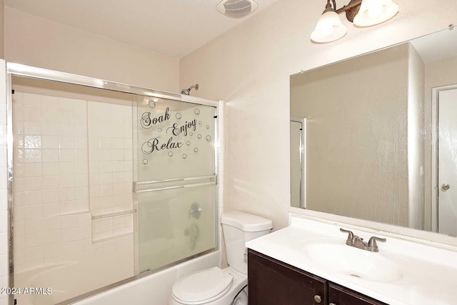 full bathroom featuring toilet, visible vents, combined bath / shower with glass door, and vanity