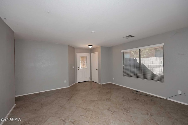 empty room with visible vents, plenty of natural light, and baseboards