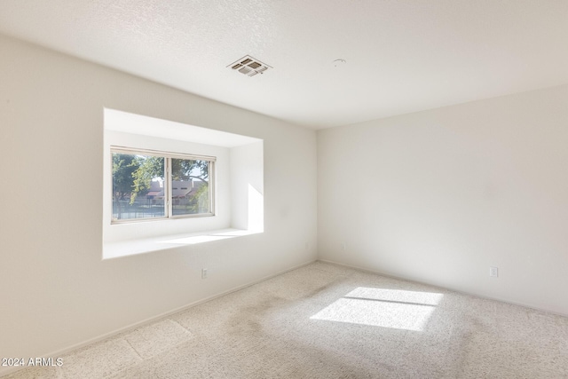 carpeted spare room with a textured ceiling