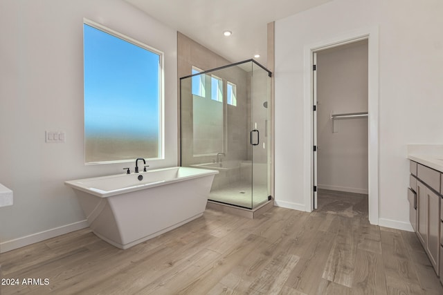 bathroom featuring hardwood / wood-style flooring, vanity, and independent shower and bath