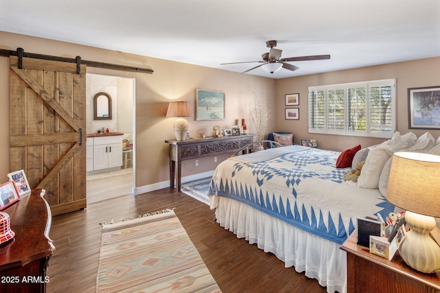 bedroom featuring a ceiling fan, a barn door, wood finished floors, and baseboards