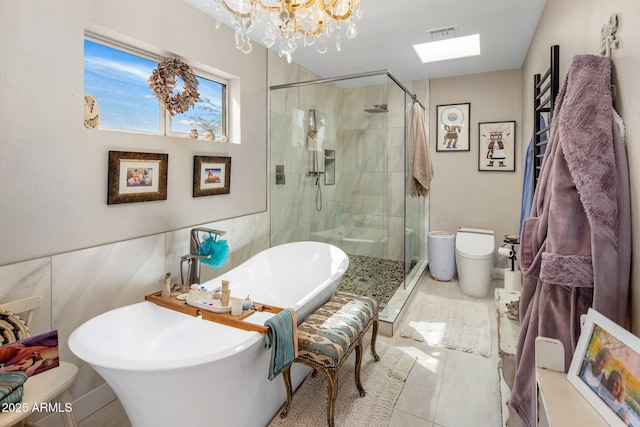 full bathroom featuring a freestanding tub, a notable chandelier, visible vents, and a stall shower