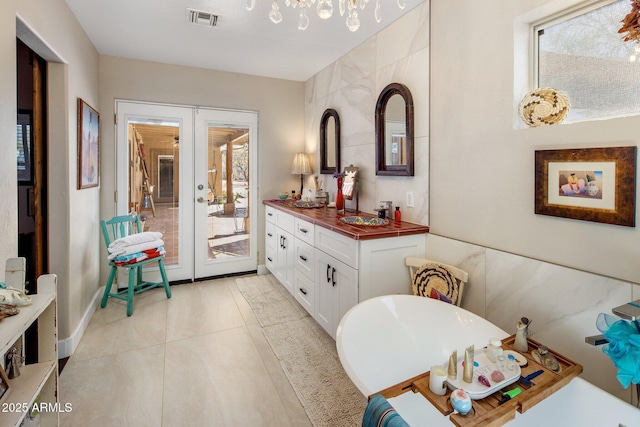 bathroom with vanity, visible vents, a freestanding tub, tile patterned flooring, and french doors