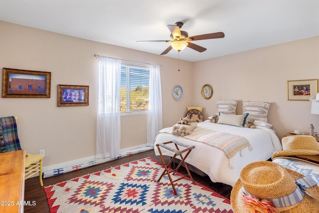 bedroom with baseboards, wood finished floors, and a ceiling fan