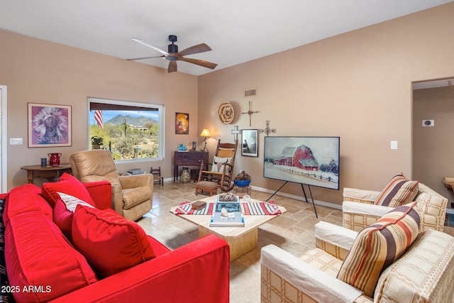 living area with visible vents, a ceiling fan, baseboards, and stone tile flooring