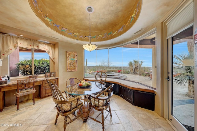 dining room featuring a tray ceiling and built in desk