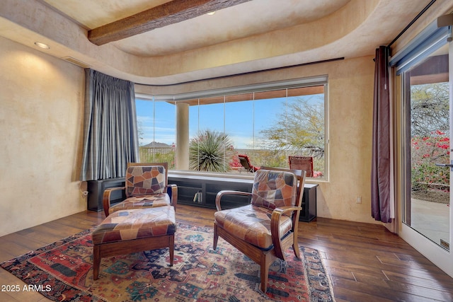 sitting room with beamed ceiling, dark hardwood / wood-style flooring, and a wealth of natural light