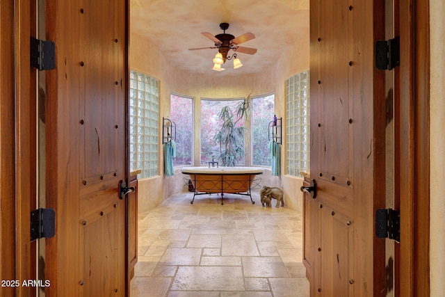 bathroom featuring ceiling fan and a bathing tub