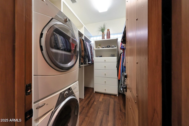 washroom with stacked washer and clothes dryer and dark wood-type flooring