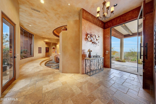 foyer featuring a towering ceiling and a notable chandelier