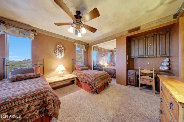 bedroom featuring ceiling fan, light colored carpet, and multiple windows