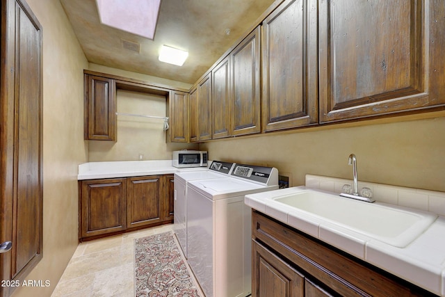 laundry area featuring cabinets, sink, and washing machine and clothes dryer