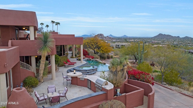 exterior space featuring area for grilling, a mountain view, and an outdoor kitchen