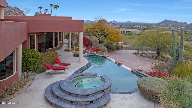 view of swimming pool featuring an in ground hot tub, a mountain view, and a patio area