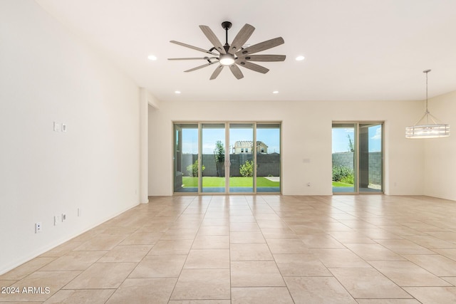 spare room with a wealth of natural light, ceiling fan, and light tile patterned floors