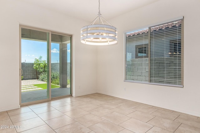 spare room with light tile patterned floors and a chandelier