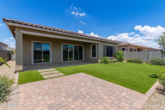 rear view of property featuring a yard and a patio