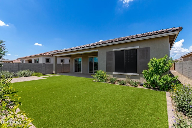 rear view of property with a patio area and a lawn