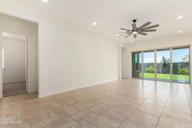 tiled spare room featuring ceiling fan