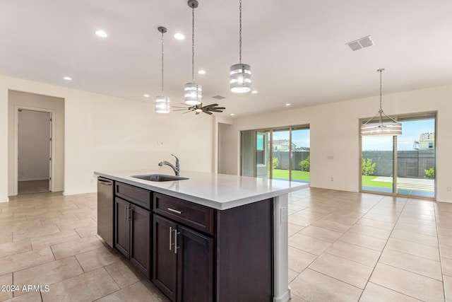 kitchen featuring stainless steel dishwasher, an island with sink, sink, and hanging light fixtures