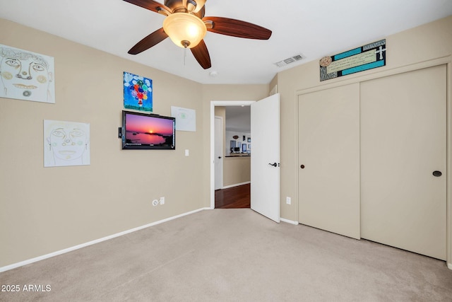 unfurnished bedroom with light carpet, a closet, and ceiling fan