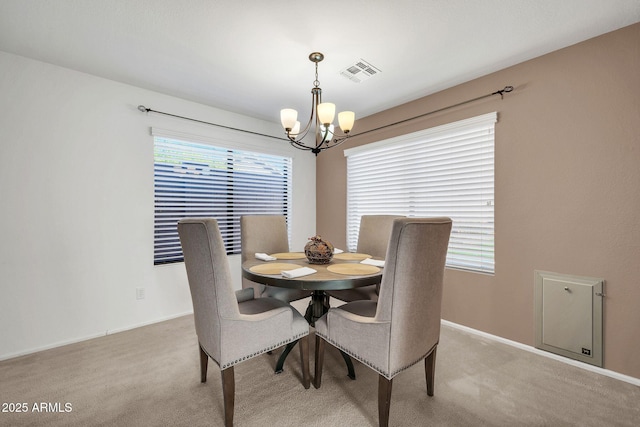 carpeted dining room featuring a wealth of natural light and a chandelier