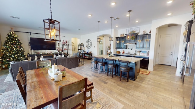 dining area with a barn door and light hardwood / wood-style floors