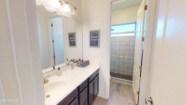 bathroom with a shower, vanity, and hardwood / wood-style flooring