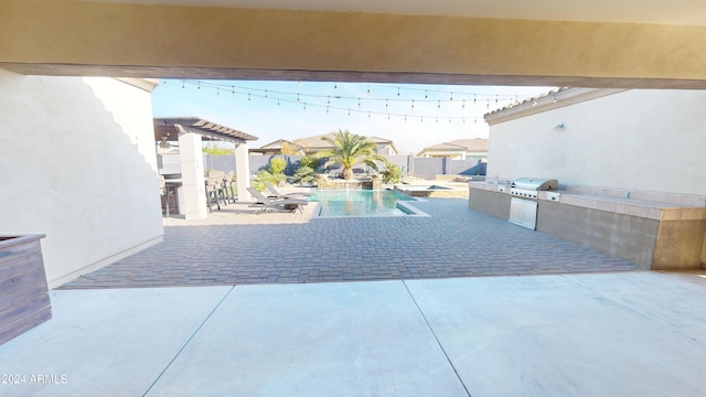 view of pool with a grill, a patio, and exterior kitchen