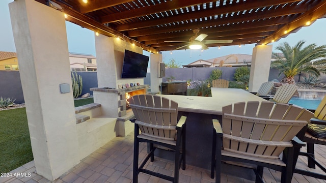 view of patio / terrace with exterior bar, a pergola, and ceiling fan