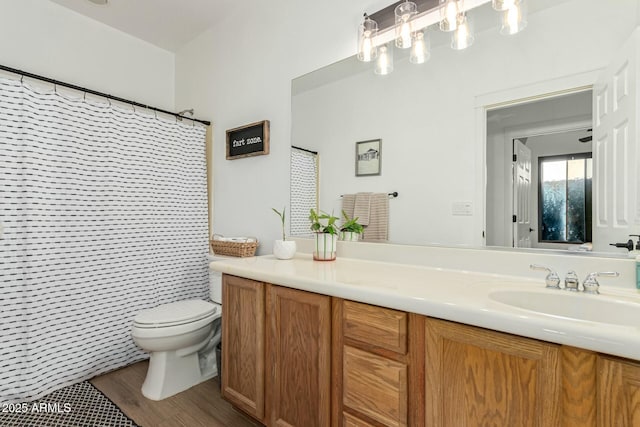 bathroom featuring vanity, toilet, curtained shower, and hardwood / wood-style floors