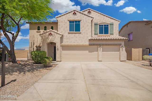 mediterranean / spanish house with fence, a garage, stucco siding, a tiled roof, and driveway