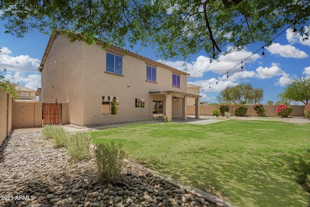 rear view of house with a fenced backyard, a patio area, and stucco siding