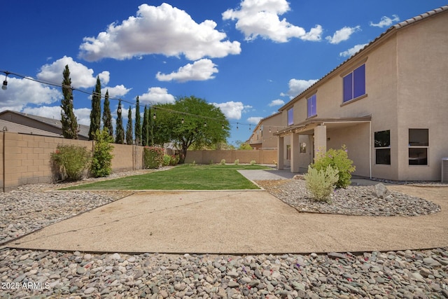 view of yard with a fenced backyard, central air condition unit, and a patio area