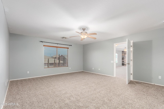 carpeted empty room featuring a ceiling fan, baseboards, and visible vents