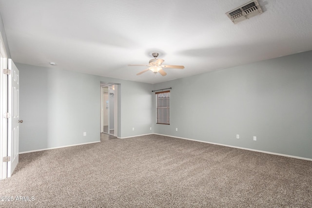 carpeted spare room with ceiling fan, visible vents, and baseboards