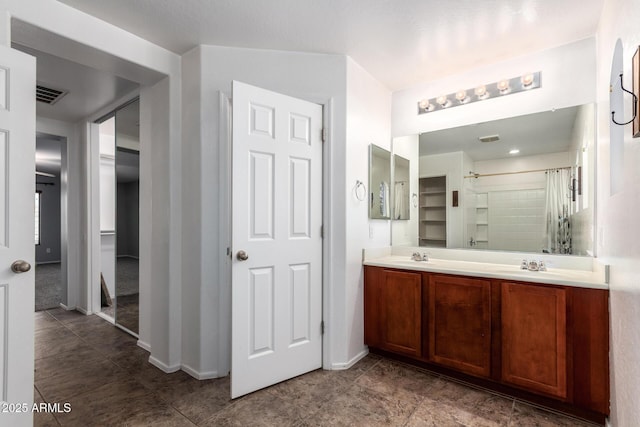 bathroom featuring double vanity, visible vents, a sink, baseboards, and a shower with shower curtain