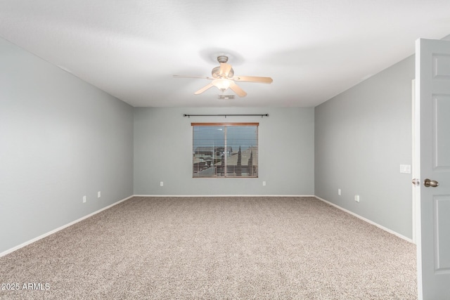 carpeted spare room with baseboards and a ceiling fan