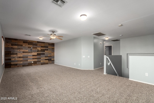 carpeted empty room featuring visible vents, baseboards, and ceiling fan