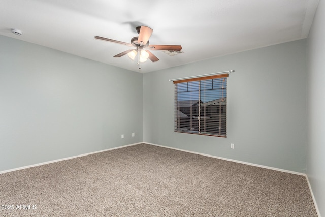 spare room featuring carpet floors, baseboards, a ceiling fan, and visible vents