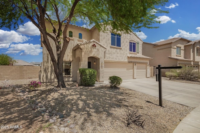 view of front of home with fence, stucco siding, a tiled roof, concrete driveway, and an attached garage