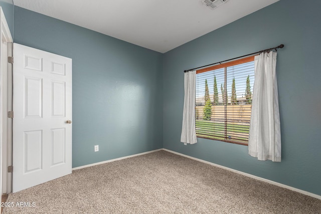 spare room featuring carpet floors, baseboards, and visible vents