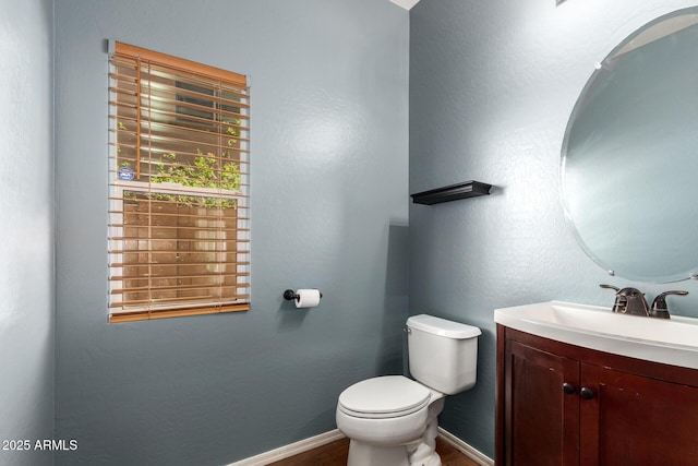 bathroom featuring vanity, baseboards, toilet, and wood finished floors
