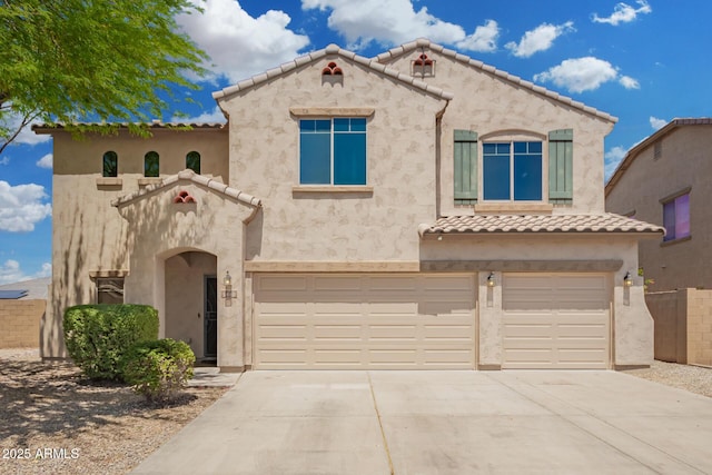 mediterranean / spanish-style home with an attached garage, stucco siding, and a tile roof