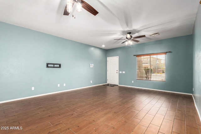spare room with visible vents, baseboards, ceiling fan, and wood finished floors