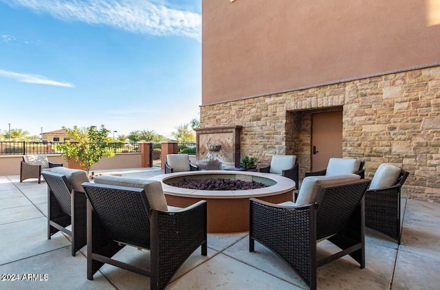 view of patio / terrace featuring an outdoor stone fireplace and an outdoor fire pit